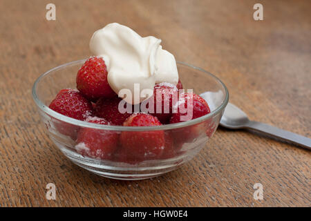 Les Fraises et la crème dans un bol en verre clair Banque D'Images