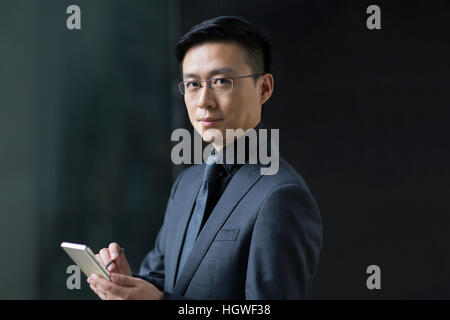 Mid adult businessman using smart phone Banque D'Images