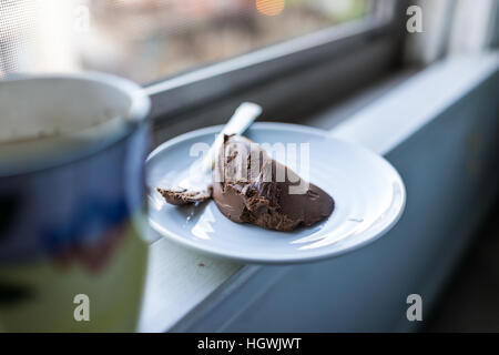 Tasse de thé chaud et gâteau au chocolat, on window sill Banque D'Images