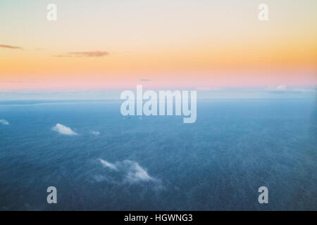 Vue aérienne du vol à haute altitude des avions sur la mer Baltique, la surface du golfe de Riga en hiver au coucher du soleil lever du soleil. Aube ensoleillée avec ciel clair et froid Banque D'Images