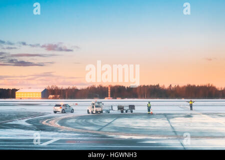 Le Maréchal de l'aéroport pour les avions de signalisation de l'équipe de l'aéroport international de contrôle en début de matinée avec beau lever ciel dramatique. Signal de l'équipe au sol Banque D'Images