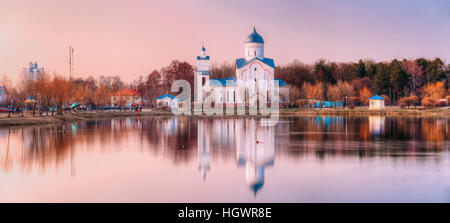 Le point de vue de l'Église chrétienne orthodoxe Alexandre Nevski avec clocher et la chapelle, sur la rive du lac à l'aube, le lever du soleil au coucher du soleil au début du printemps, Forest Park Banque D'Images