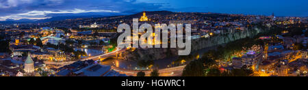 Tbilissi, Géorgie. La magnifique vue panoramique Vue de dessus du paysage urbain en soirée avec un éclairage lumineux tous les célèbres monuments et sites sous bleu dramatique C Banque D'Images