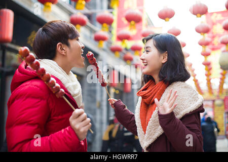 Jeune couple avec fruits confits haw célébrant le Nouvel An chinois Banque D'Images