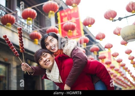 Jeune couple avec fruits confits haw célébrant le Nouvel An chinois Banque D'Images