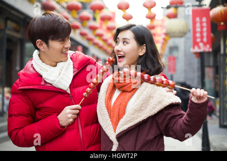 Jeune couple avec fruits confits haw célébrant le Nouvel An chinois Banque D'Images