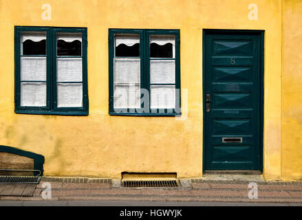 La façade d'une vieille maison de ville, à Elseneur, Danemark avec plâtre des murs jaune et vert peint des fenêtres et des portes Banque D'Images