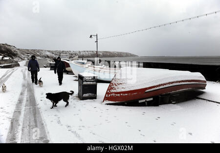 Les promeneurs de chiens sur le front de mer de St Francis Bay sur la côte est, comme l'Ecosse et le nord de l'Angleterre ont fait l'objet d'une couverture de neige alors que la côte est a été renforcé pour une onde de tempête à vendredi midi. Banque D'Images