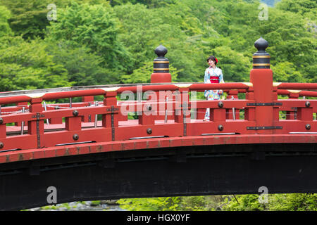 Geisha habillé femme traversant le Pont Rouge, Nikko, Japon. Banque D'Images