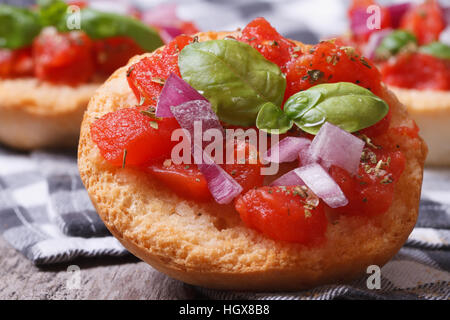 L'Italien bruschetta à la tomate, l'oignon et le basilic close-up sur la table Banque D'Images