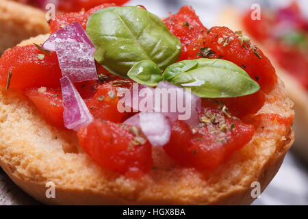 L'Italien bruschetta à la tomate, l'oignon et le basilic macro sur la table Banque D'Images