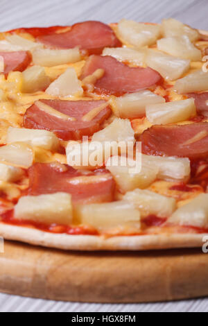Pizza hawaïenne à l'ananas et au jambon sur la table. close up vertical. Banque D'Images
