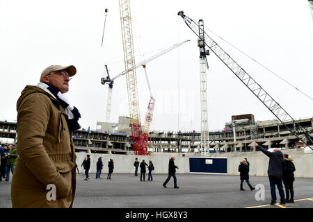 Un Tottenham Hotspur fans se penche sur les travaux de construction en cours sur le nouveau stade avant le premier match de championnat à White Hart Lane, London. Banque D'Images