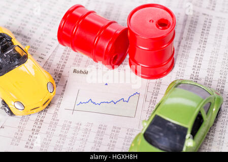 Diagramme avec une courbe ascendante entouré par les voitures et les barils de pétrole. Banque D'Images