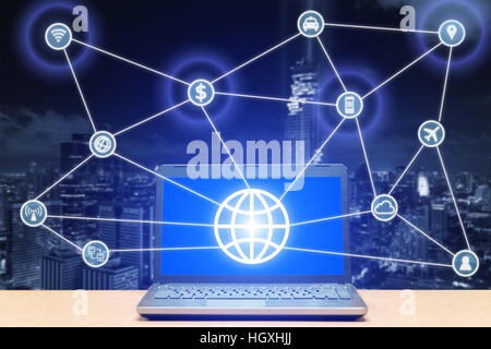 Ordinateur portable sur le bureau en bois avec la technologie et de l'icône de communication. La technologie et de la communication concept. Banque D'Images