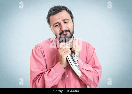 Businessman holding sneakers Banque D'Images