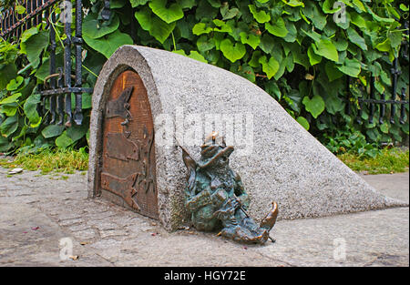 Le petit nain de figurine garde l'entrée de la mine de trésors, dormir s'appuyant sur le mur Banque D'Images