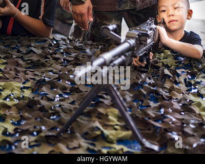 Bangkok, Thaïlande. 14 Jan, 2017. Un enfant regarde vers le bas le sightes d'une mitrailleuse FN MAG pendant la journée des enfants à des activités de la Garde du roi, 2e Division de cavalerie à base de Bangkok. La Thaïlande Fête Nationale de l'enfance est célébrée le deuxième samedi de janvier. Connu sous le nom de ''Wan Dek'' en Thaïlande, Children's Day est célébré à donner aux enfants la possibilité de s'amuser et de faire connaître leur rôle important dans le développement du pays. Credit : ZUMA Press, Inc./Alamy Live News Banque D'Images