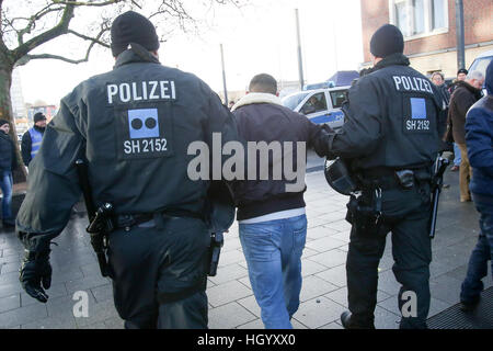 Kiel, Allemagne. 14 Jan, 2017. L'arrestation des policiers un participant d'une manifestation pro-kurde à Kiel, Allemagne, 14 janvier 2017. Trois personnes ont été placées en garde à vue pendant la démonstration. Après une heure, les participants ont terminé l'ensemble de l'événement. Photo : Marques Bodo Bodo/marque/dpa/Alamy Live News Banque D'Images