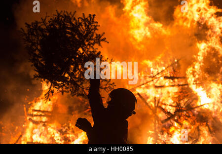 Gundelfingen, Allemagne. 14 Jan, 2017. Un pompier lance un arbre de Noël géant sur un feu à Gundelfingen, Allemagne, 14 janvier 2017. La communauté est la collecte des arbres de Noël qui sera ensuite brûlé à la périphérie de la ville. Plusieurs centaines de résidents de Gundelfingen prennent part. Photo : Patrick Seeger/dpa dpa : Crédit photo alliance/Alamy Live News Banque D'Images