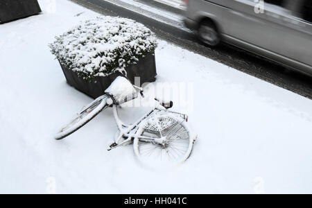 Munich, Allemagne. 15 Jan, 2017. Un vélo couvert de neige fraîche à Munich, Allemagne, 15 janvier 2017. Plusieurs centimètres de neige fraîche sont tombés pendant la nuit à Munich. Photo : Tobias Hase/dpa/Alamy Live News Banque D'Images