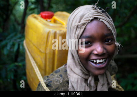 L'église Debre Sina Maryam, Lac Tana, Bahir Dar, l'Éthiopie. Une fille recueille l'eau d'un bien à proximité de prendre sa maison à côté Debram Maryam monastère sur Banque D'Images