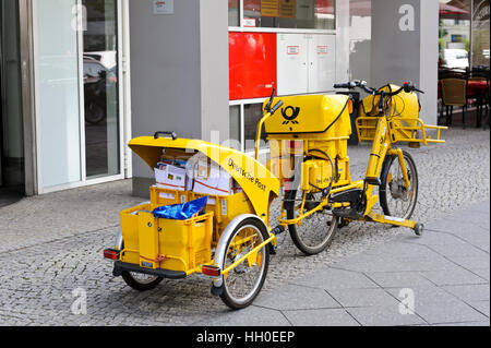 La livraison du courrier d'un vélo jaune garé à l'extérieur d'un bureau à Berlin, Allemagne. Banque D'Images