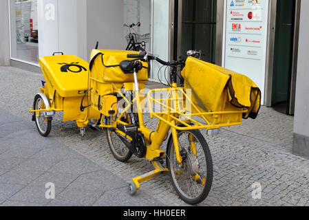 La livraison du courrier d'un vélo jaune garé à l'extérieur d'un bureau à Berlin, Allemagne. Banque D'Images