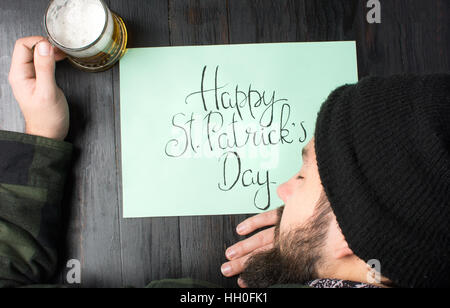 L'homme de dormir sur une table lors d'St Patricks day celebration Banque D'Images