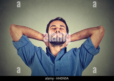 Closeup portrait of happy young man in blue shirt regardant vers le haut dans la pensée se détendre ou faire une sieste isolé sur fond de mur gris Banque D'Images