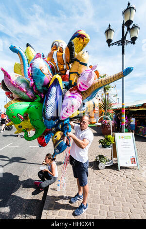 L'Angleterre, Ramsgate. Vendeur de ballons sur mer, avec des masses de ballons aux couleurs vives. Soleil, ciel bleu. Banque D'Images