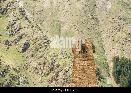 Ancienne Vieille Tour en pierre sur fond de montagne dans Village Sioni, Kazbegi district, région de Mtskheta-Mtianeti, Géorgie. Printemps ou Été. Fa Banque D'Images