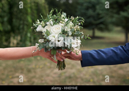 Le marié la mariée donne un beau bouquet de mariée Banque D'Images