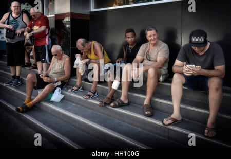 Groupe d'hommes assis sur les marches et passer le temps de la journée Banque D'Images