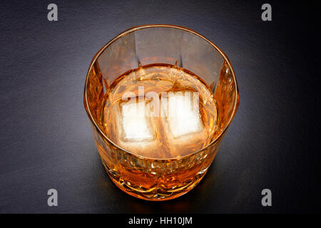 Verser dans le verre de whisky avec deux cube de glace Banque D'Images