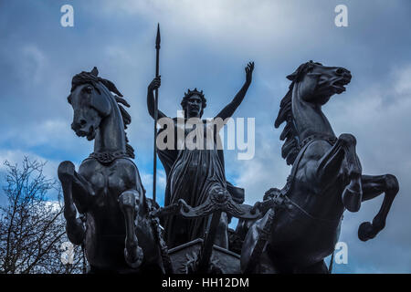 Libre de regarder droit devant et de reine Boadicea équitation son chariot avec deux chevaux noirs et tenant une lance Banque D'Images