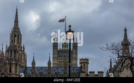 L'éclairage avec ampoule allumée en début de soirée libre des Chambres du Parlement avec le drapeau de l'Union britannique volant dans le ciel Banque D'Images