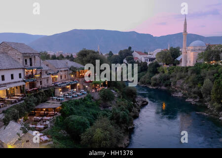 Restaurants le long de la Neretva à Mostar au crépuscule Banque D'Images