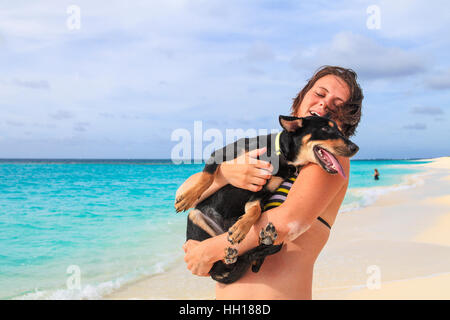 Femme à Shoal Bay holding dog elle a sauvé à Anguilla Banque D'Images