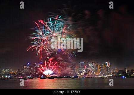 Flashy lumineux des feux d'artifice dans le ciel des boules de Sydney CBD sur la ville au cours de l'an d'Australie se reflétant dans l'eau trouble d'artifice de Sydney Banque D'Images