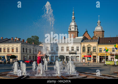 Enfants jouant à fontaine papale sur chaude journée d'été, Rynek (Place du marché) à Nowy Sacz, Malopolska, Pologne Banque D'Images