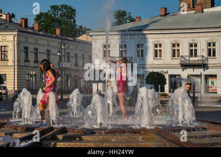 Enfants jouant à fontaine papale sur chaude journée d'été, Rynek (Place du marché) à Nowy Sacz, Malopolska, Pologne Banque D'Images