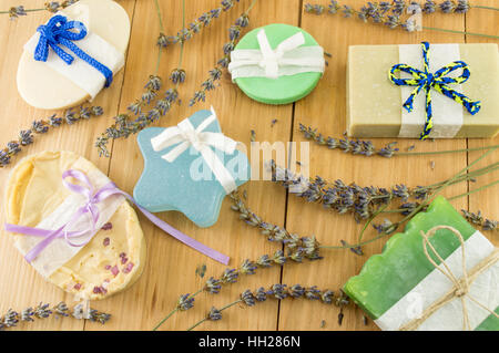 Les savons artisanaux colorés avec des rubans sur une table en bois Banque D'Images