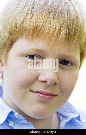 Portrait of cute blonde boy in blue shirt Banque D'Images