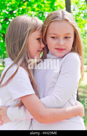 Photo de deux jeunes filles en été chuchotée smiling Banque D'Images