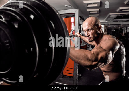 Bodybuilder chauve préparait pour l'exercice d'haltères avec in gym Banque D'Images