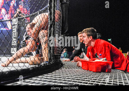 Les entraîneurs donnent des conseils à leurs fighter dans l'anneau au cours d'une cage de MMA lutte. Banque D'Images