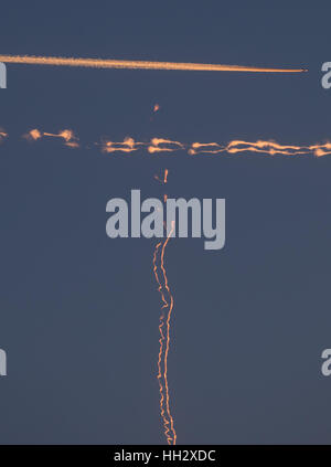 Un avion du passager (haut) croise deux traînées de condensation la foudre en rouge pendant le coucher du soleil à Francfort/Main, Allemagne, le 6 janvier 2017. Photo : Frank Rumpenhorst/dpa Banque D'Images