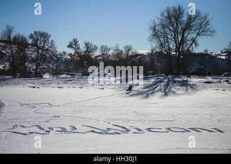 Dakota du Nord, USA. 15 Jan, 2017. Un homme marche à travers la rivière gelée Cannonball où l'expression, ''Mni Wiconi, '' la traduction de ''l'eau est la vie, '' est gravée de l'empreinte à l'Oceti Oyate Camp à Cannon Ball, dans le Dakota du Nord. Les écologistes ont fait du camping sur le site situé sur le corps du génie de l'Armée de terre pendant des mois pour protester contre la construction du pipe-line, mais accès Dakota sur plan du site mobile de nouveau dans les semaines à venir dans l'article Rock Indian Reservation terre en raison d'inondations. Crédit : Joel Angel Juarez/ZUMA/Alamy Fil Live News Banque D'Images