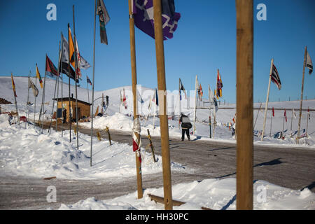 Dakota du Nord, USA. 15 Jan, 2017. Un militant de l'eau passe devant une rangée de drapeaux près de l'entrée de l'Oceti Oyate Camp à Cannon Ball, dans le Dakota du Nord. Les écologistes ont fait du camping sur le site situé sur le corps du génie de l'Armée de terre pendant des mois pour protester contre la construction du pipe-line, mais accès Dakota sur plan du site mobile de nouveau dans les semaines à venir dans l'article Rock Indian Reservation terre en raison d'inondations. Crédit : Joel Angel Juarez/ZUMA/Alamy Fil Live News Banque D'Images